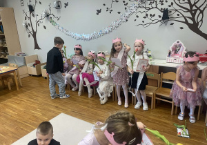Chłopcy wręczają dziewczynkom kwiaty