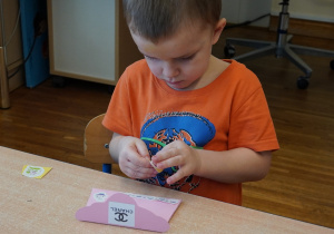 chłopiec przykleja naklejki na torebkę