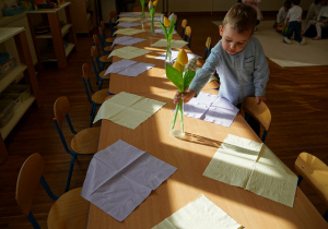 Olek stawia na stole wazon