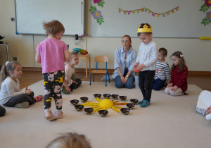 chłopiec trzyma miseczkę z koralikami