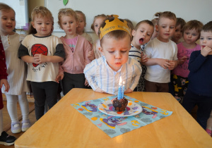 chłopiec zdmuchuje świeczkę