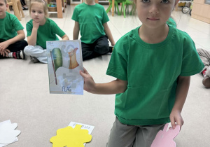 dziewczynka siedzi w kole i pokazuje wylosowany obrazek i flagą Irlandii