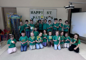 dzieci pozują do wspólnego zdjęcia z gadżetami związanymi z dniem Św. Patryka