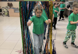 dziewczynka przechodzi przez tęczową kurtynę