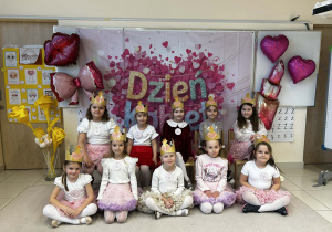 Dziewczynki w koronach pozują na tle dekoracji