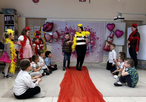 Chłopiec prowadzi panią po czerwonym dywanie