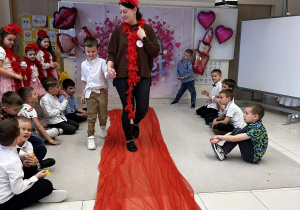 Chłopiec prowadzi panią po czerwonym dywanie