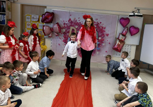 Chłopiec prowadzi panią po czerwonym dywanie