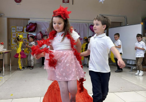 Chłopiec prowadzi koleżankę po czerwonym dywanie