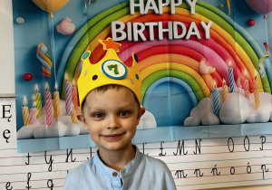 Borysek pozuje w koronie na urodzinowym tle