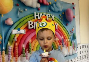 Chłopiec zdmuchuje świeczkę