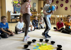 Chłopiec trzyma globus a dziewczynka rozkłada koraliki