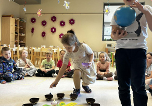 Chłopiec trzyma globus a dziewczynka rozkłada koraliki