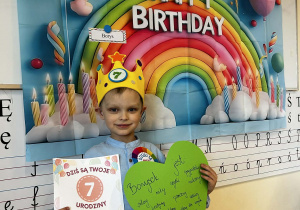 Chłopiec pozuje z dyplomem i serduszkiem