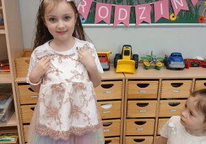 Dziewczynka prezentuje sukienkę z dzieciństwa