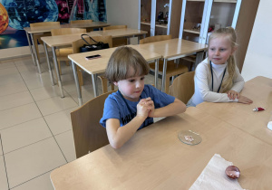 chłopczyk probuje zgnieść jajko owinięte w folię aluminiową