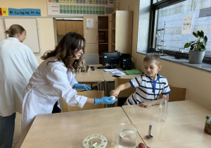pani od chemii trzyma jajko bez skorupki a chłopczyk je dotyka