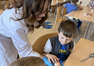 pani od chemii trzyma jajko bez skorupki a chłopczyk je dotyka