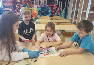 dzieci i uczenica liceum malują mazakami kawałek ręcznika papierowego