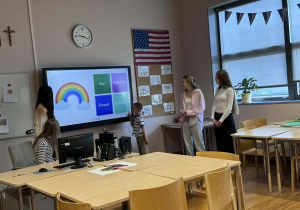 chłopiec zaznacza na tablicy multimedialnej podpis do obrazka