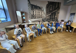 dzieci z zamkniętymi oczami siedzą w półkolu i grają w grę "what is missing"?