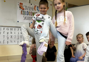 Chłopiec i dziewczynka podnoszą skarpetki za pomocą palców u stóp