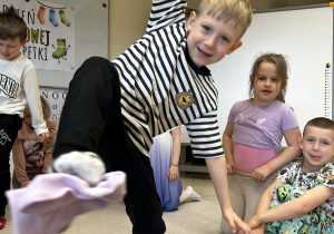 Chłopiec podnosi skarpetę za pomocą palców u stóp