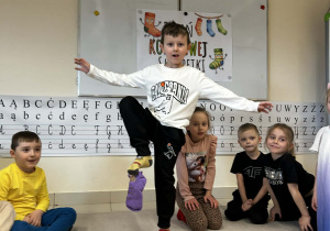 Chłopiec podnosi skarpetę za pomocą palców u stóp