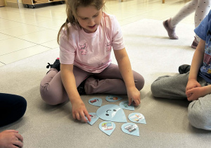 Dziewczynka segreguje odpowiednie ilustracje o oszczędzaniu i marnowaniu wody