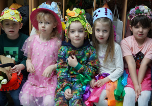 dzieci w kapeluszach siedzą na ławce