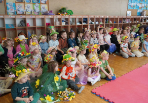 dzieci siedzą na podłodze i ławkach