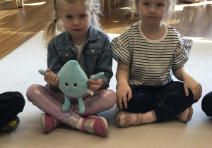 dzieci podają sobie maskotke kropelkę wody