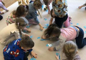 dzieci zbieraja wycięte kropelki z papieru