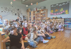 dzieci siedzą na dywanie