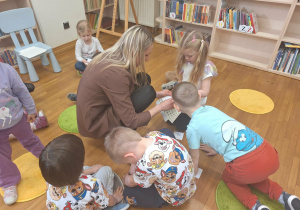 pani Ola rozdaje dzieciom naklejki