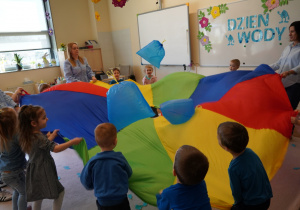 dzieci podrzucają foliowe krople na chuście animacyjnej