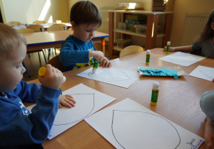 chłopcy wyklejają papierem krople wody