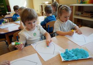 dziewczynki wyklejają papierem krople wody