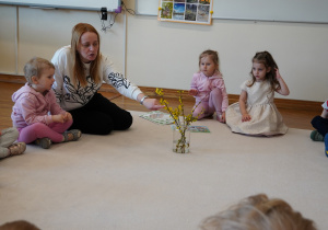 pani pokazuje gałązki forsycji