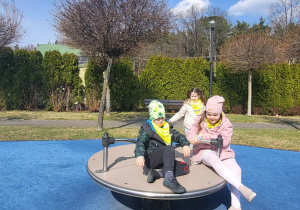 dzieci bawią się na urządzeniach terenowych