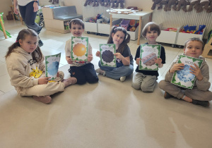 dzieci prezentują ilustracje z czynnikami co jest potrzebne do wzrostu roślin