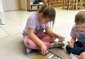 dziewczynki układają obrazki z kwiatami i podpisują nazwy