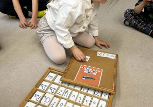 dziewczynka układa napis nazwę ptaka