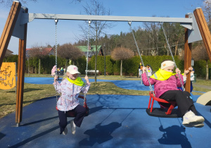 dziewczynki huśtają się na placu zabaw na huśtawkach