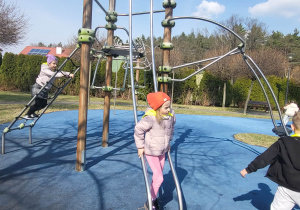 dzieci wspinają się na urządzeniach terenowych