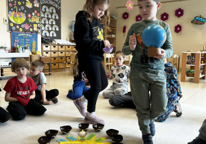 Chłopiec trzyma globus a dziewczynka rozkłada koraliki