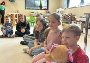 Chłopiec trzyma misia i składa życzenia koleżance