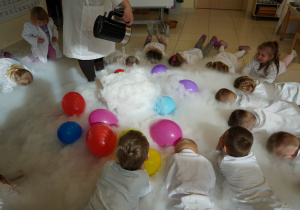 dzieci z balonikami chowają się w białej chmurze