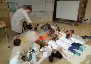 dzieci leżą na dywanie w chmurach z pary