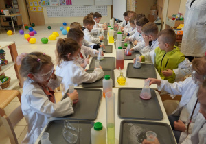 dzieci mieszają kolorowy płyn